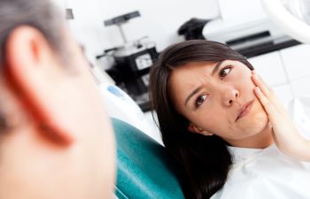 A concerened woman with a dental pain during a dental appointment.