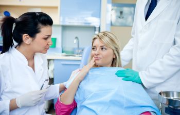 A concerned woman with dental issue talking to a dentist.