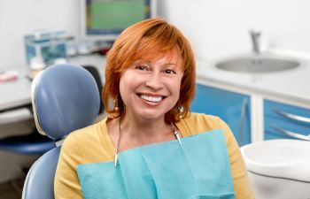 Satisfied mature woman with a perfect smile sitting in a dental chair.